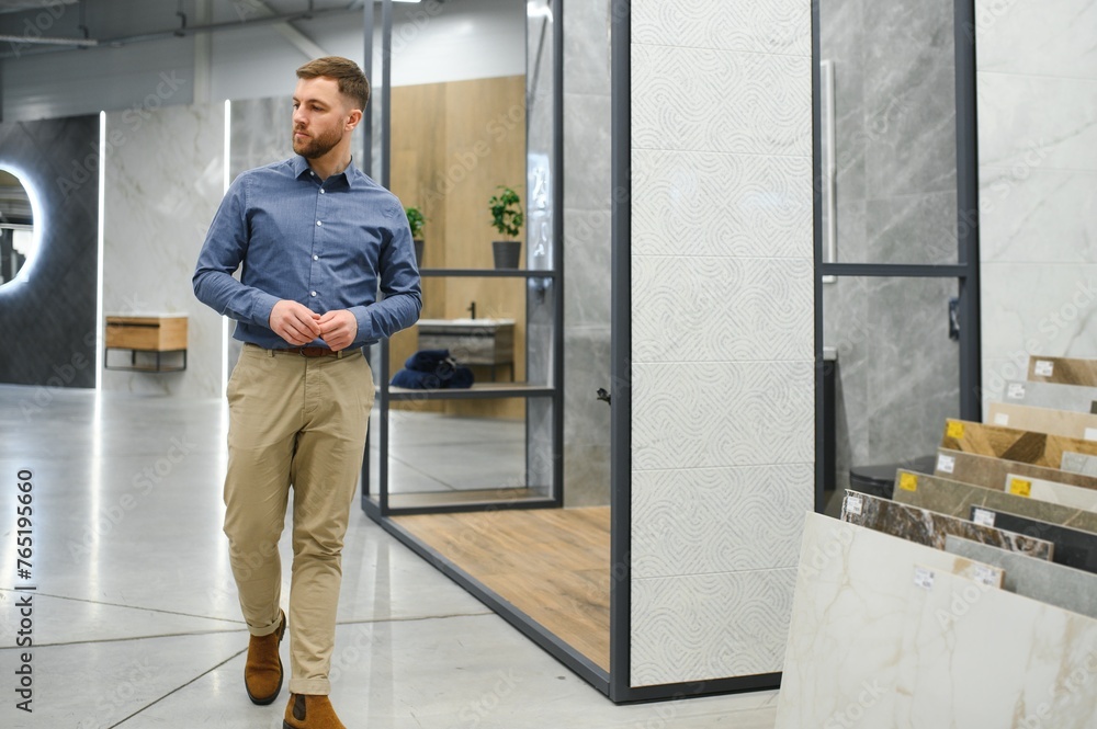 Middle age man choosing ceramic tiles and utensils for his home bathroom Middle age man choosing ceramic tiles and utensils for his home bathroom
