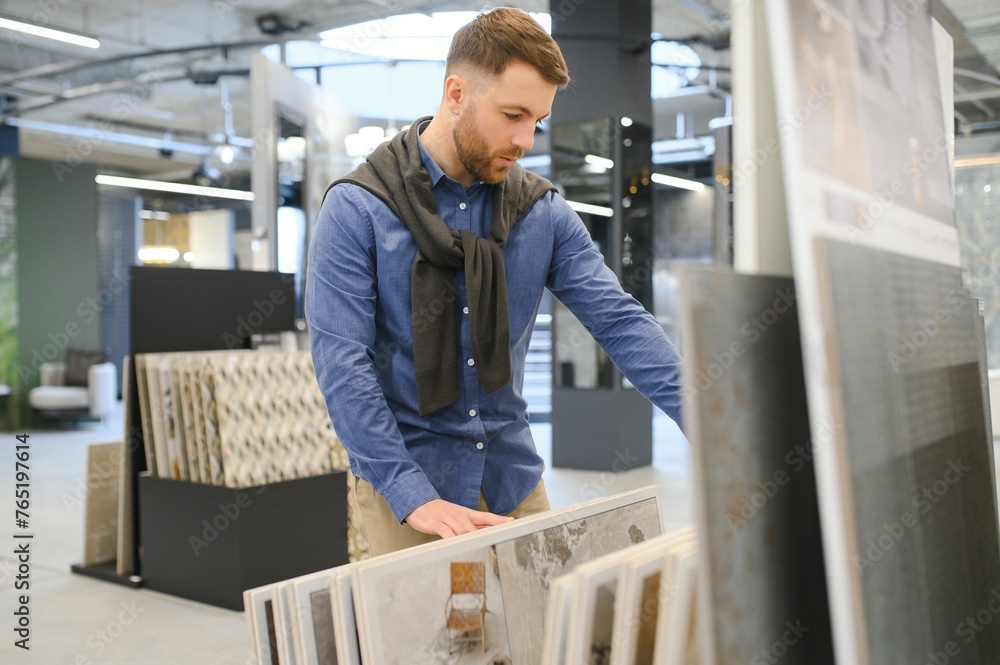 Middle age man choosing ceramic tiles and utensils for his home bathroom Middle age man choosing ceramic tiles and utensils for his home bathroom