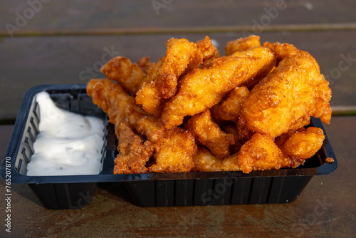 Outdoor eating of diep-fried cod fish pieces served with remoulade sauce, Dutch street food photo