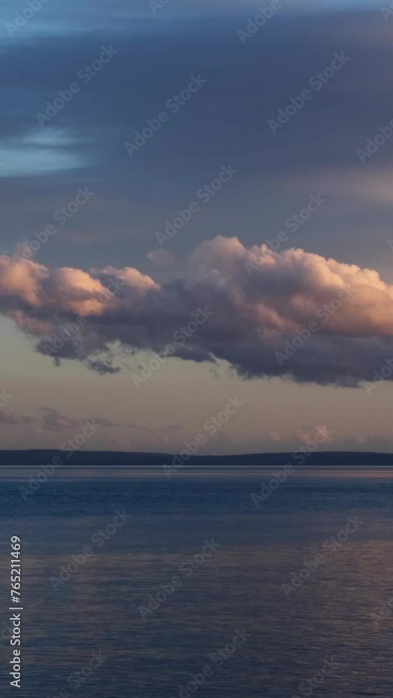 Fast motion of fluffy clouds moving in straight line above the Mediterranean sea near Opatija, Croatia. Magnificent nature, sunset time, beautiful water reflections, last colourful rays of the sun. Fast motion of fluffy clouds moving in straight line above the Mediterranean sea near Opatija, Croatia. Magnificent nature, sunset time, beautiful water reflections, last colourful rays of the sun.