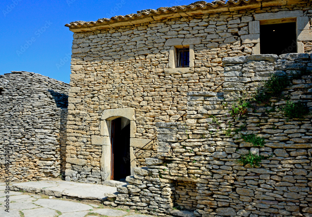Obraz premium kamienny dom w prowansji, kamienny dom na tle niebieskiego nieba, simple stone house in provence, Village des Bories in France