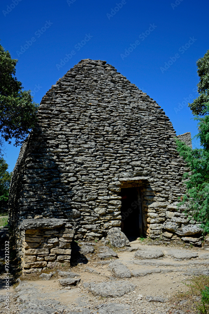 Naklejka premium kamienny dom w prowansji, kamienny dom na tle niebieskiego nieba, simple stone house in provence, Village des Bories in France