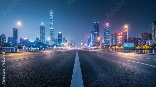 In Guangzhou, China, there is a modern city skyline and an asphalt road illuminated at night.