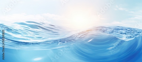 A close up view of a wave cresting in the ocean, with the sun shining brightly in the background