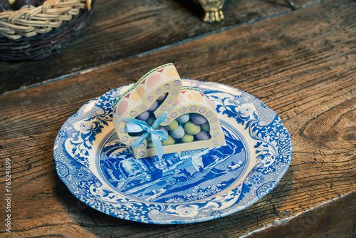 Decorative Blue and White Plate with Easter Egg Box on Wooden Table