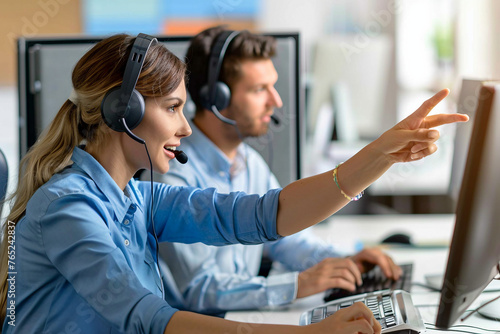 Female call center agent helping male colleague pointing at computer