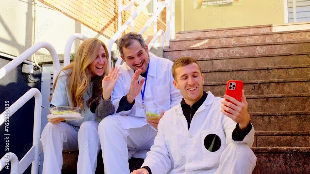 Small group of hospital workers taking selfie sitting on stairs, outside the hospital. Small group of hospital workers taking selfie sitting on stairs, outside the hospital.