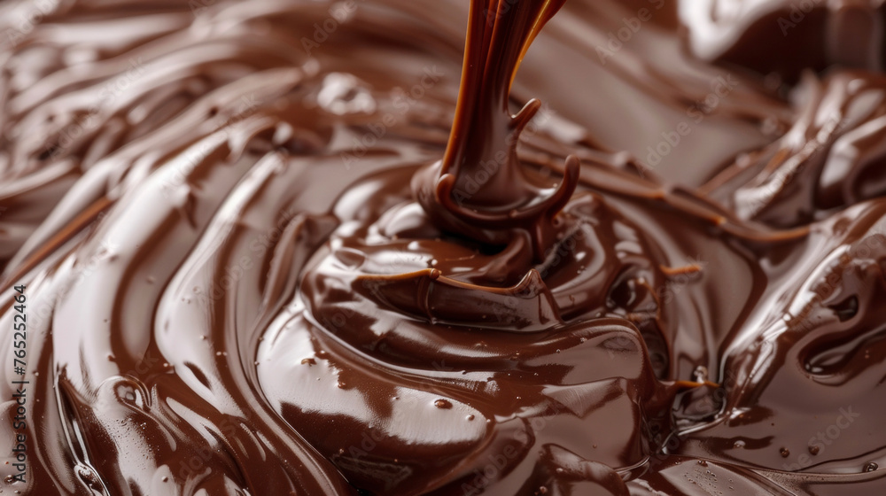 A close-up view of a pool of melted chocolate with a silver spoon partially submerged in it. A close-up view of a pool of melted chocolate with a silver spoon partially submerged in it.