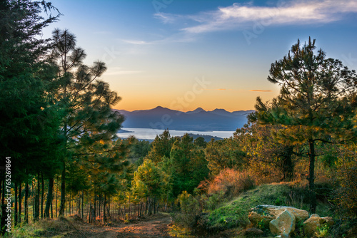 Fototapeta Naklejka Na Ścianę i Meble -  Mountain with many pine trees and a view of Lake Patzcuaro and mountains in the background.