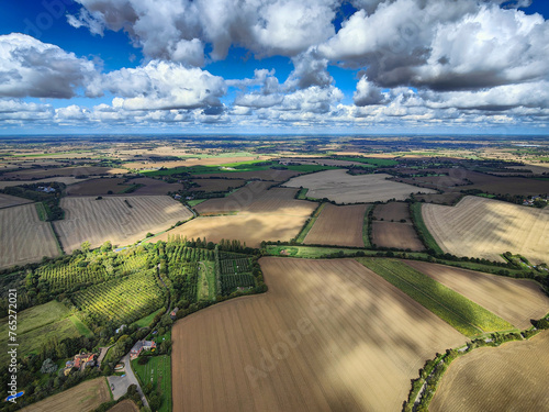 Aerial view of a typical British countryside patchwork. Agriculture fields, farm rural landscape, blue sky and white clouds. Suffolk, England, UK photo