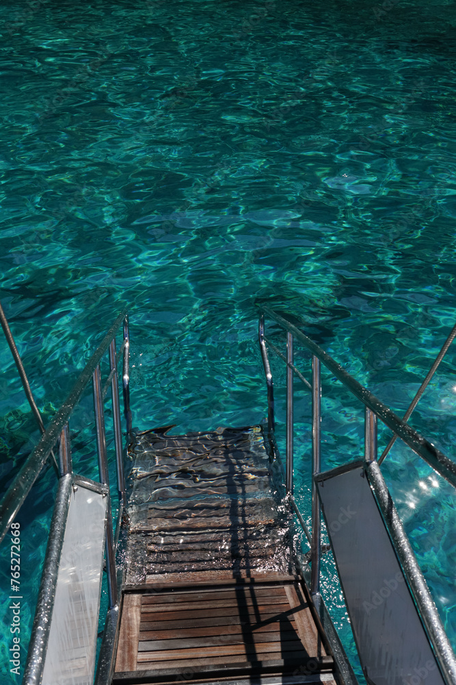 clear water with stairs leading down into the crystal blue waters