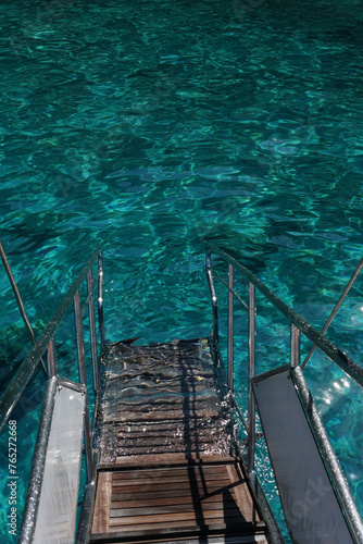 clear water with stairs leading down into the crystal blue waters © Rita
