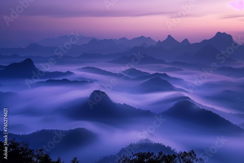 A panoramic view showing the ethereal beauty of mountain silhouettes rising from the mist at dawn.
