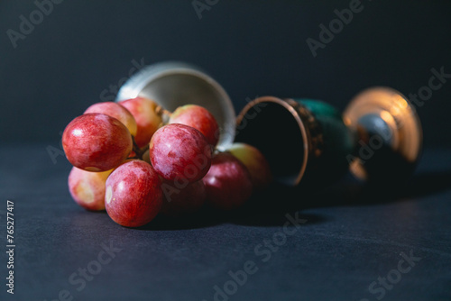 red grapes fallen on the table from a wine tumbler  (ID: 765277417)