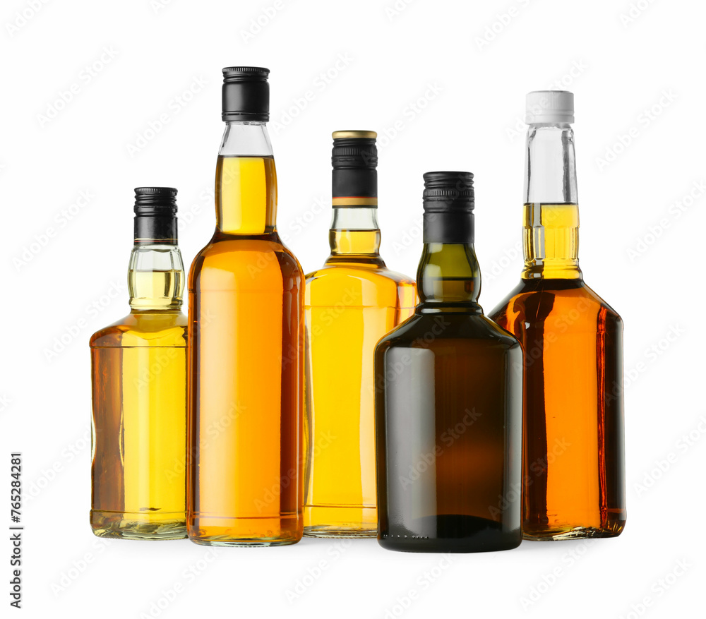 Different sorts of whiskey in glass bottles isolated on white Different sorts of whiskey in glass bottles isolated on white