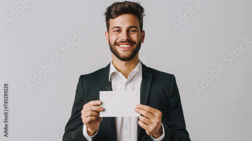  Cheerful businessman presents blank business card, engaging with camera, isolated on white, ready for networking.