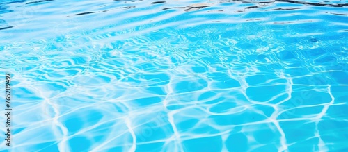 A close-up view of a serene pool filled with transparent water reflecting the clear blue sky above