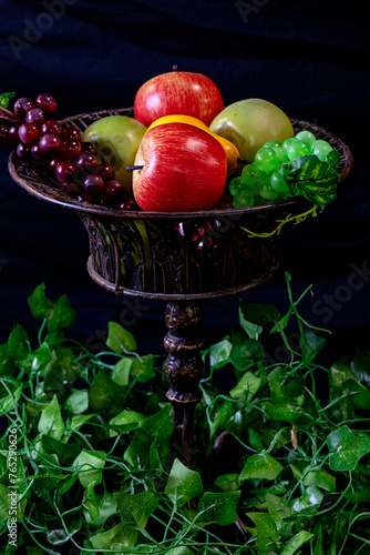 Fruits in old vintage bowl with greenery around (ID: 765290626)