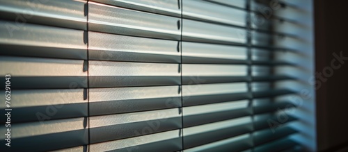 Blinds are shut, but beams of light are filtering through the closed slats.