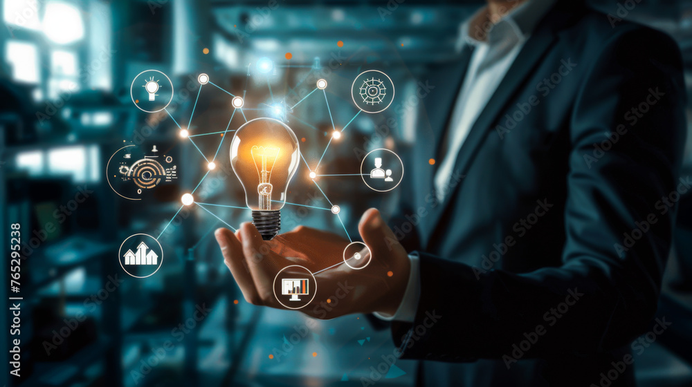 A person is holding a light bulb in their hand, surrounded by a network of icons and symbols. Concept of innovation and creativity, as the light bulb represents a source of inspiration and new ideas A person is holding a light bulb in their hand, surrounded by a network of icons and symbols. Concept of innovation and creativity, as the light bulb represents a source of inspiration and new ideas