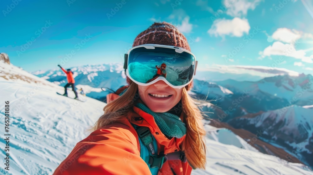 A woman snowboarder taking a selfie on top of a mountain, capturing the panoramic vista behind her 