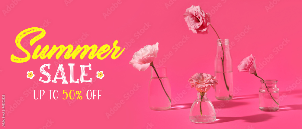 Glass bottles with beautiful eustoma flowers on pink background