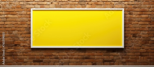 A bright yellow picture frame is hanging securely on a textured brick wall