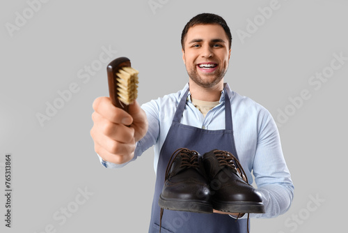 Male shoemaker with brush a...