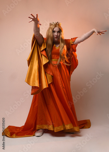 Full length portrait of plus sized woman blonde hair  wearing historical medieval fantasy gown with long flowing sleeves  golden crown of royal queen. Standing pose  isolated studio background.