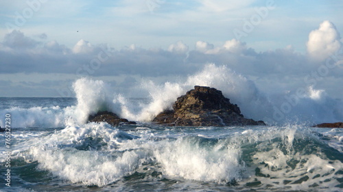 Waves breaking around rocks just offshore, on the rocky coastline in Zipolite, Mexico
