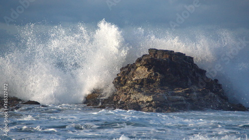 Waves breaking around rocks just offshore, on the rocky coastline in Zipolite, Mexico