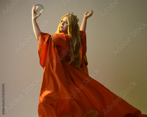 close up portrait of plus sized blonde woman, wearing historical medieval fantasy gown, golden crown of royal queen. gestural hands posing holding magic crystal seer orb, isolated studio background.