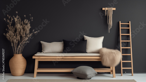 A wooden bench with a cream cushion, black pillows, and fur throw blanket against a dark wall with a decorative wall hanging and dried flowers in a vase. photo