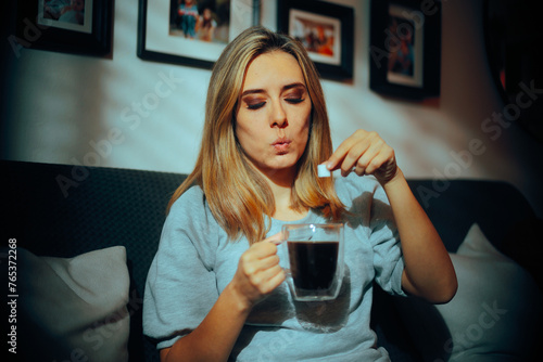 Fotografia Woman Putting one Cube of Sugar in her Black Coffee