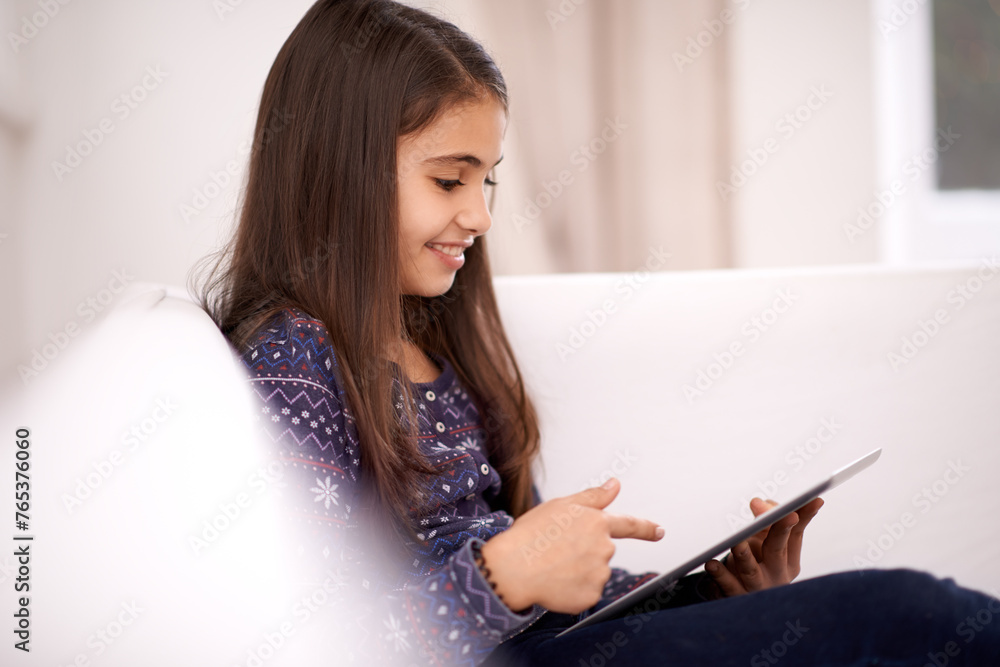 Relax, home or kid with tablet for streaming, playing games or watching fun videos on movie website. Social media, online or happy girl with technology to download on app or reading ebook on couch Relax, home or kid with tablet for streaming, playing games or watching fun videos on movie website. Social media, online or happy girl with technology to download on app or reading ebook on couch