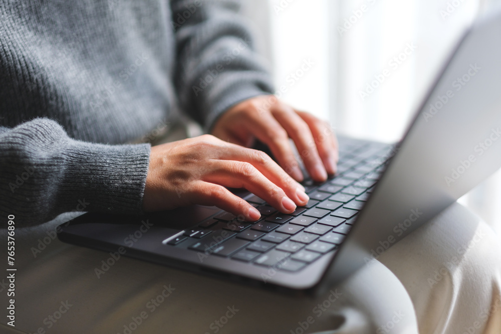 Closeup image of a woman typing on laptop computer at home Closeup image of a woman typing on laptop computer at home