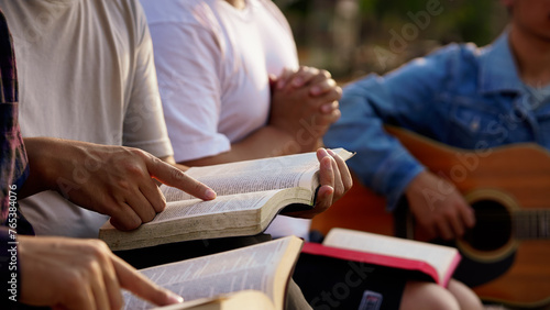 The people read and studied the bible at the park and prayed together. sharing the gospel with a friend. Holy Bible study reading together on Sunday.Studying the Word Of God With Friends. Education.