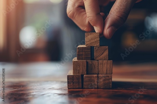 A close-up photo of a hand placing a wooden block on a stable stack symbolizing strategic financial planning