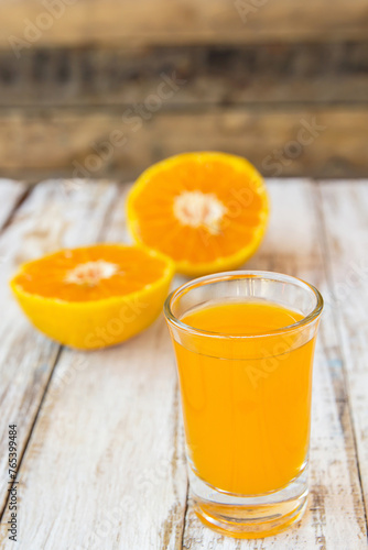 Glass of freshly pressed orange juice on wooden table