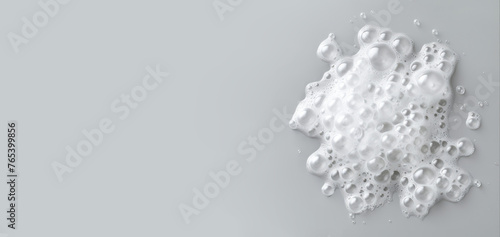 Shampoo or soap foam with bubbles on neutral grey background. Horizontal banner, template for advertising with space for text.