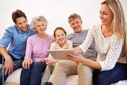 Generations, tablet and family with smile, home and relax on sofa of living room for bonding. Grandparents, father and mother with technology for girl, growth and development of child with internet