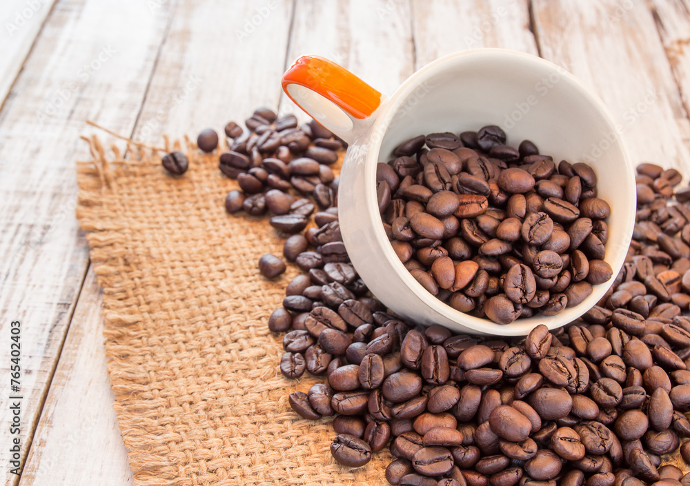Coffee beans and coffee cup on wooden background