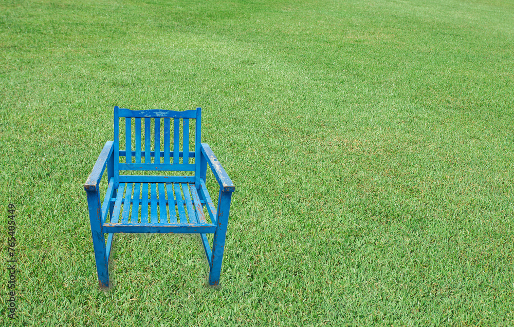 Antique blue wooden chair on a green grass background Antique blue wooden chair on a green grass background