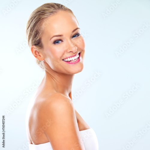 Portrait, woman and skincare in studio with dermatology, cosmetic treatment or facial glow. Female person, happy and smile with confidence for self care, healthy skin or wellness on blue background