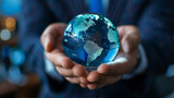 Close-up of a businessman's hands cradling a transparent globe, symbolizing global business and environmental responsibility.