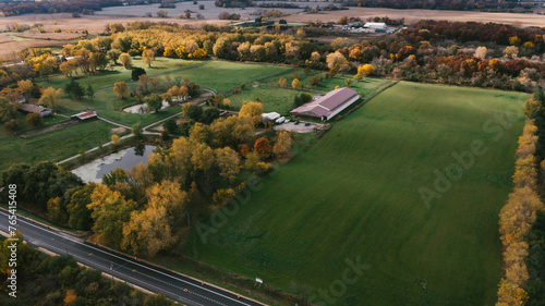 Horse and farm property in fall with barn and pond photo