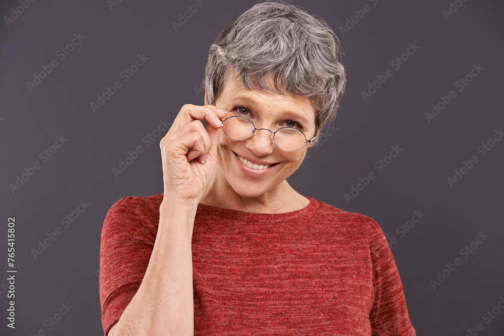 Happy, portrait and senior woman with glasses in studio for vision, optometry or frame sale on grey background. Eye care, testing or face of old lady model smile for pensioner, spectacles or discount Happy, portrait and senior woman with glasses in studio for vision, optometry or frame sale on grey background. Eye care, testing or face of old lady model smile for pensioner, spectacles or discount