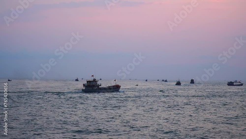 Seascape in the early morning with boats going in and out of the seaport.