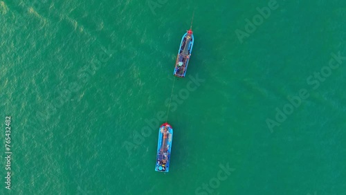 Two fishing boats of Vietnamese fishermen are anchored at sea with an aerial view.