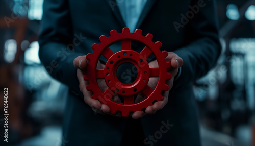 businessman holding red gear cog